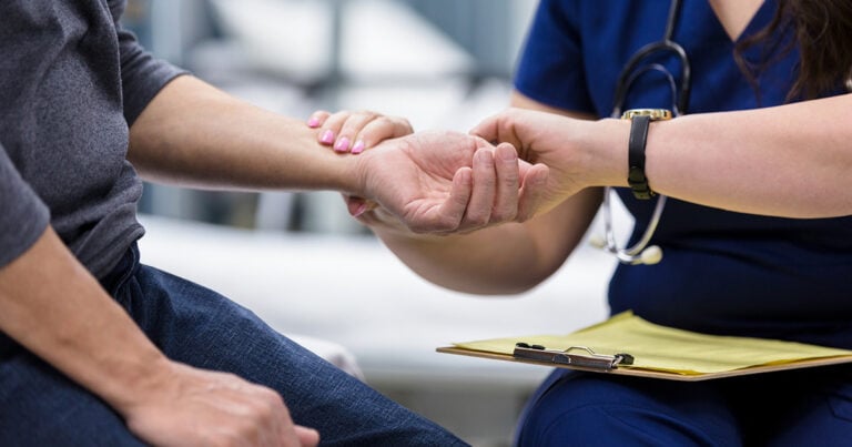 A nurse takes a patient's pulse